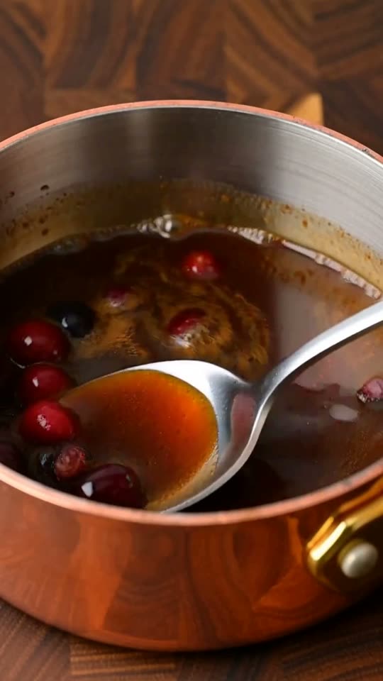 Step 6: Deglaze roasting pan drippings with rich turkey bone broth, simmering with tart cranberries and maple syrup into a glist