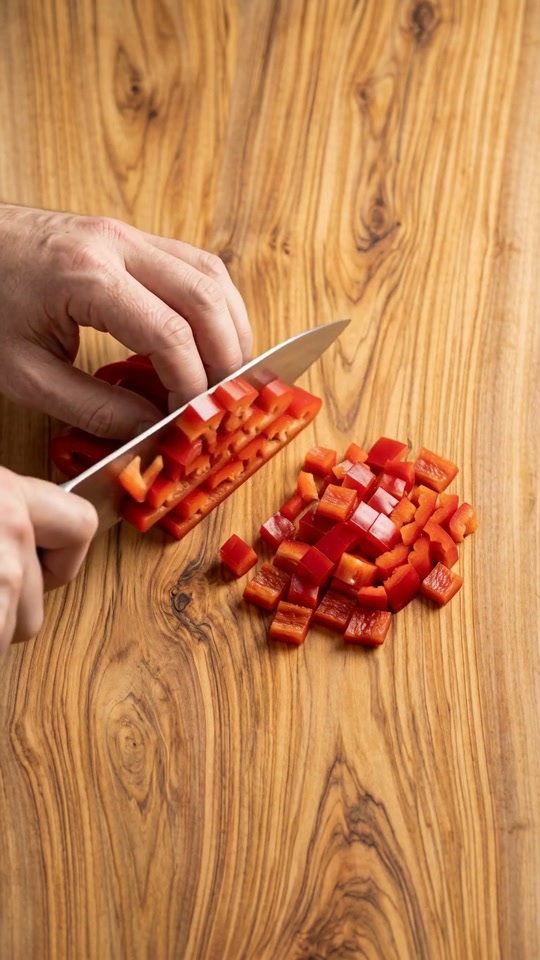 Step 2: Add the finely diced yellow onion, diced red bell pepper, and a pinch of sea salt